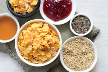 Cereal flakes without sugar, accompanied by seeds, jam and honey