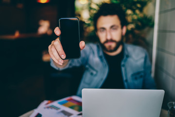 Busy casual man showing smartphone