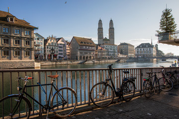 Bicycles and beautiful view of historic city center of Zurich with famous Grossmunster Church,...