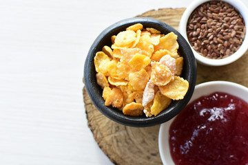 Cereal flakes without sugar, accompanied by seeds, jam and honey