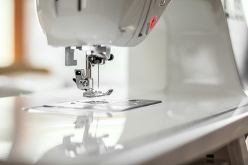 Close-up of sewing machine's presser foot and needle in selective focus