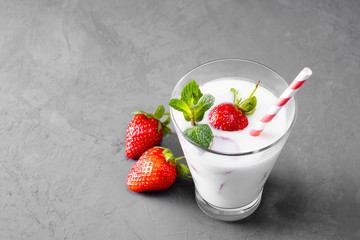 Glass of milkshake with strawberries and mint on a concrete surface. Kefir cocktail with strawberries and banana. close-up. Strawberry protein cocktail on a gray concrete background.