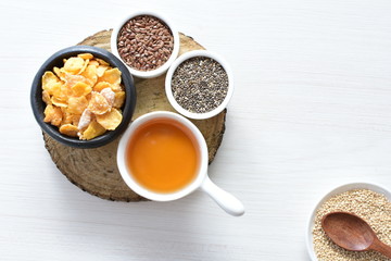 Cereal flakes without sugar, accompanied by seeds, jam and honey