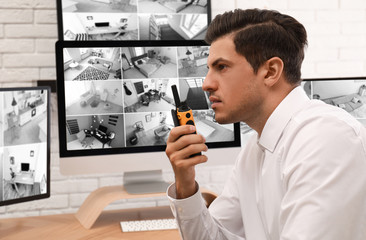 Male security guard with portable transmitter at workplace