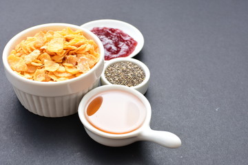 Cereal flakes without sugar, accompanied by seeds, jam and honey