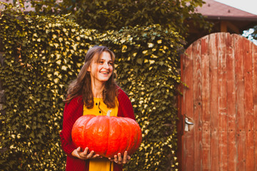 Portrait of beautiful cheerful woman with pumpkin