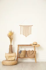 Fotobehang Boho Stylish room with wooden table and wicker bags near white wall. Interior design  © New Africa