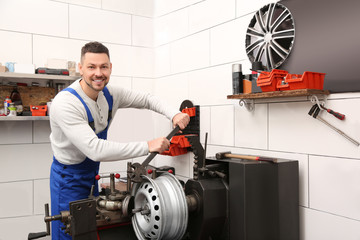 Mechanic working with car disk lathe machine at tire service