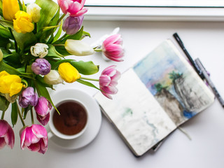 cup of coffee and flowers on wooden table