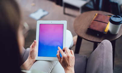 Unrecognizable female remote worker browsing internet on tablet