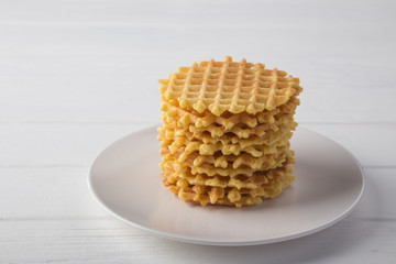 Delicious waffles with fresh fruit and berries on a white wooden table. Waffles with strawberries and blueberries. Free space for text. Traditional belgian waffles with fresh fruit. Stack of waffles w