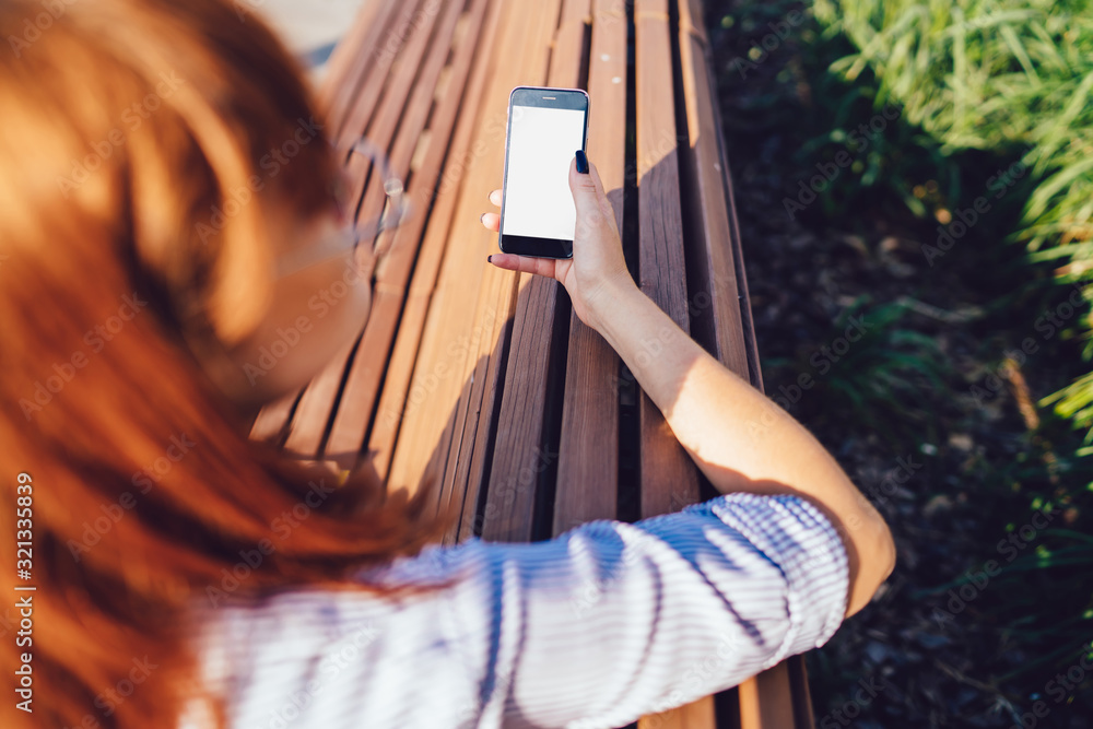 Aufkleber back view of female user holding smartphone with blank screen sending text messages via app online, 