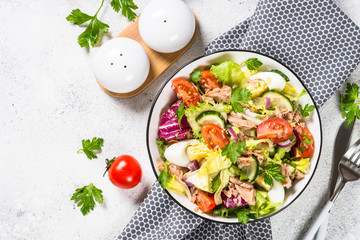 Tuna salad with green leaves, eggs and vegetables.