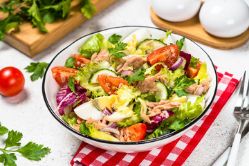 Tuna salad with green leaves, eggs and vegetables.