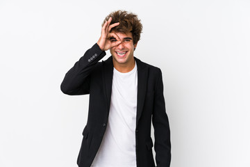 Young caucasian business man against a white background isolated excited keeping ok gesture on eye.