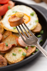 Fried sausage on a fork with mustard. Selective focus. Breakfast. Grilled Sausage on a fork. close-up image of sausage and fork