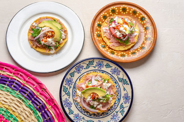 Mexican ham toast also called tostadas with beans and cheese on white background