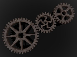 Three metal gears connected to each other on an asphalt background