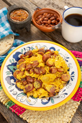 Scrambled eggs with sausage breakfast on wooden background
