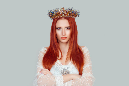 Grumpy beauty queen. Portrait, skeptical, serious young woman looking suspicious, disapproval on face arms crossed folded pretty woman with crystal crown on head isolated on light gray