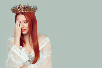 Sad beauty queen. Unhappy pretty woman with crystal crown on head looking away sadly isolated on light green gray background wall. Negative emotions face expressions reaction