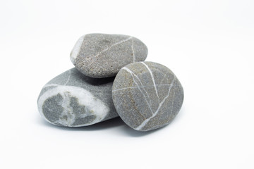 Pebbles on a white background. Stones with natural striped pattern. Four small stones lie on top of...