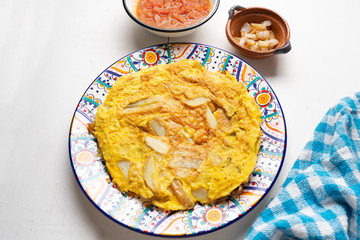 Spanish scrambled eggs with potatoes called tortilla or tapa on white background