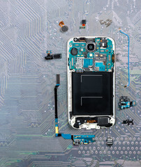 cell phone is broken down into individual parts on a circuit board
