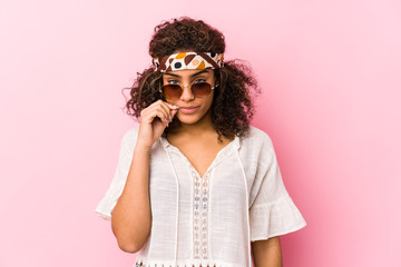 Young african american hipster woman isolated on pink background with fingers on lips keeping a secret.