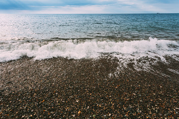 Sea Ocean Waves Washing Pebble Stones Beach At Cloudy Summer Day
