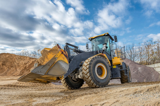 A wheel loader travels through a sand and gravel warehouse.