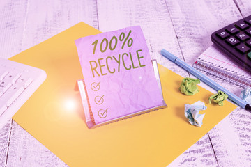 Handwriting text 100 Percent Recycle. Conceptual photo contains 100 percent postconsumer recovered material Notepaper stand on buffer wire in between computer keyboard and math sheets