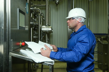 man engineer near computer establishes a production line in a factory. Factory worker is...