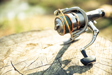 fishing reel is on stump close up on a sunny day with copy space