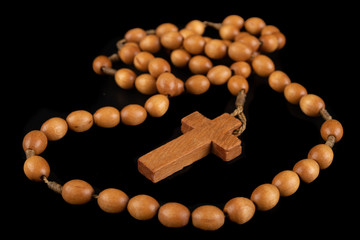 Wooden rosary arranged on the table. Prayer accessories.