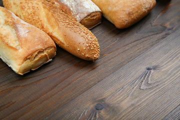 different kinds of bread on wooden background top view with copy space