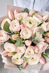Bunch pale pink tulips and ranunculus flowers with green eucalyptus. The work of the florist at a flower shop.