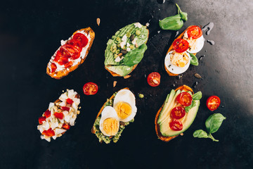 Sweet potato toasts with avocado, eggs, tomatoes and sesame seeds