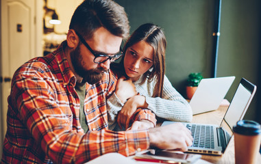 Young woman comforting upset boyfriend during work in cafe