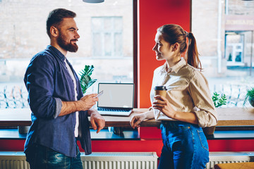 Obraz premium Cheerful freelancers talking during break in cafe
