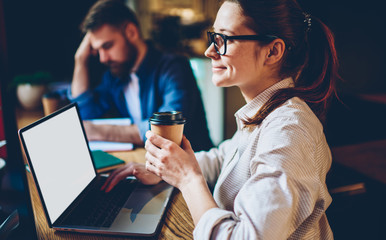 Dreamy woman working on project using laptop in cafe