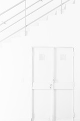 Interior space completely white: wall, door and staircase with handrail