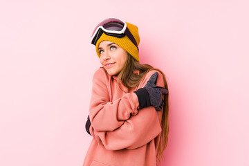 Young caucasian woman wearing a ski clothes isolated hugs, smiling carefree and happy.
