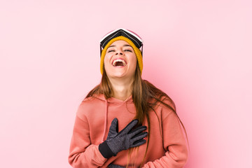 Young caucasian woman wearing a ski clothes isolated laughs happily and has fun keeping hands on stomach.