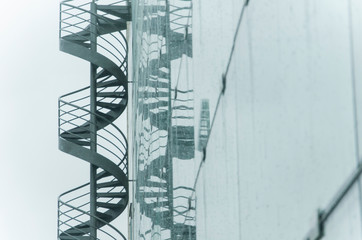 Spiral staircase on the outside of a building, reflected in it