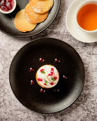 Cupcakes with whipped white vanila cream with pancakes and berry jam, a cup of black coffee americano for breakfast, background. Food and drink concept.
