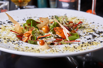 Salad with honey agaric mushroom and potato. A hearty nice salad for the festive table. Lettuce leaves, greenery, arugula, mushrooms chanterelles and dried tomatoes.