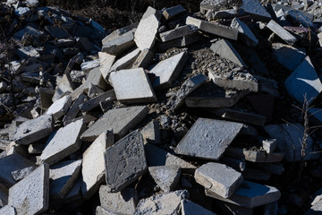 A pile of broken street tiles with cement and sand