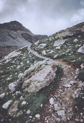 Thorny road in the mountains on the way to the top in cloudy weather