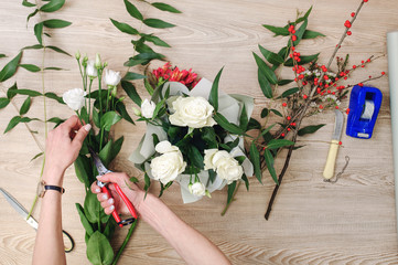 Fototapeta na wymiar Gardener's in the flower shop make bouquet. Lifestyle flower shop. Beautiful flower composition. Detail.